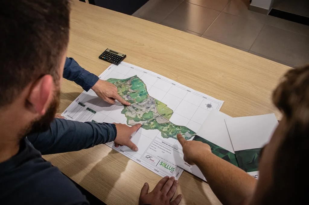 Equipe analisando mapas para o planejamento florestal